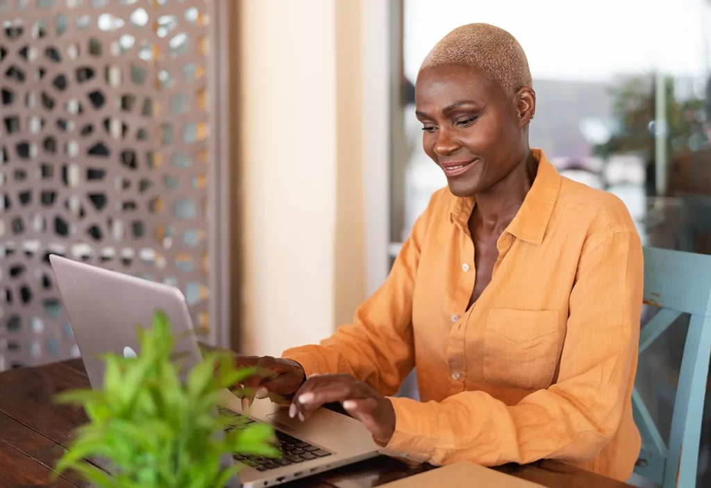 african-woman-working-on-laptop-in-bar-restaurant-afro_39885034